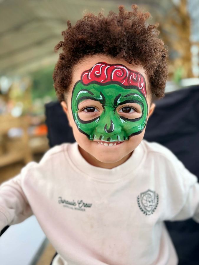 Boy with a green zombie full face design for Halloween, face painting by In His Image, Morristown TN