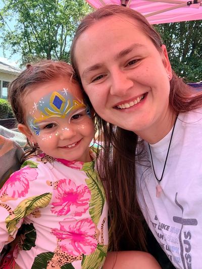Ashley with a toddler wearing a blue and gold crown design, face painting by In His Image, Morristown TN